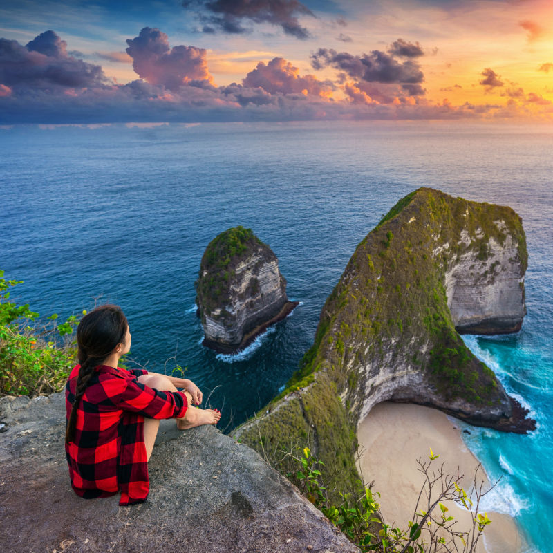 Tourist-Looks-Out-Over-Sunset-From-Kelingking-Beach-Clifftop-in-Bali