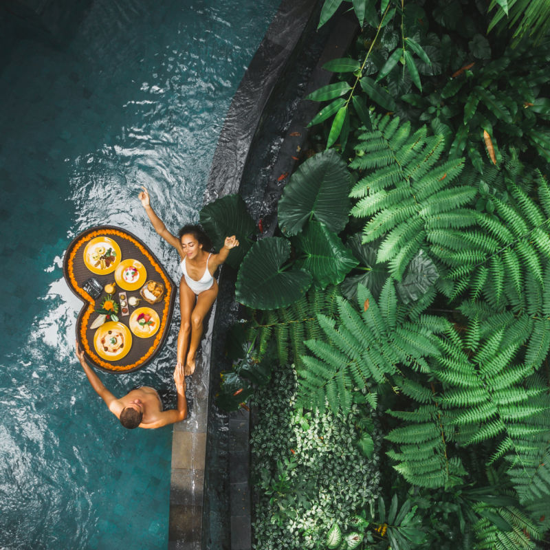 Tourist-couple-enjoy-floating-breakfast-in-pool-in-Bali