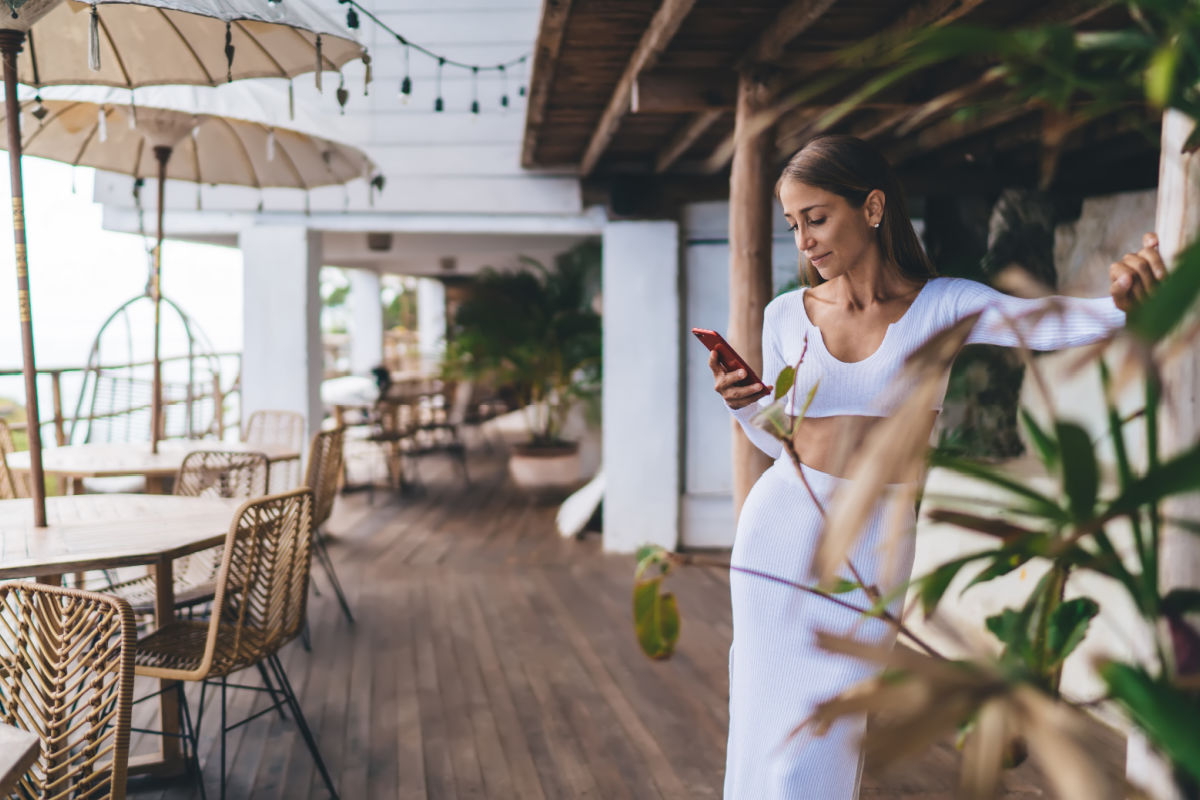 Woman dressed in white in Bali looks at her phone.jpg