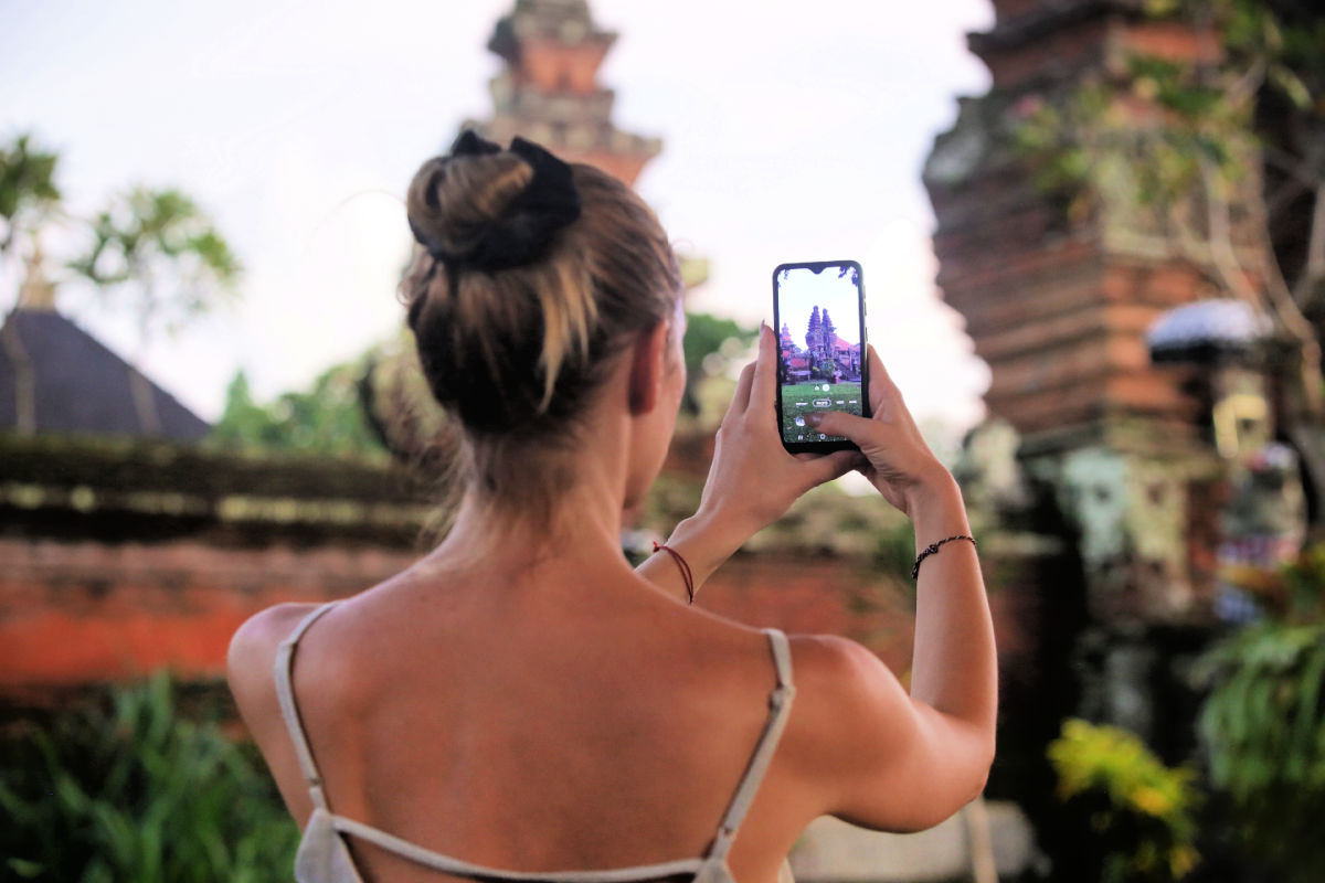 Woman takes photo of Bali temple on her phone.jpg