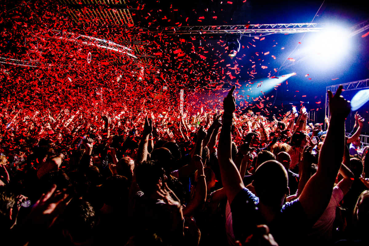 Partygoers dance under red lights and confettii in Bali.jpg