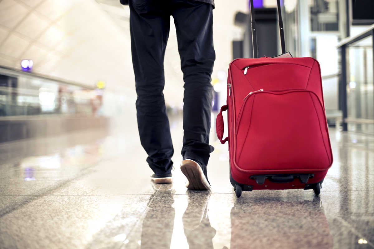 Man Walks Through airport With Wheelie case Luggage Bag.jpg