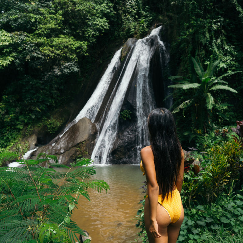 Woman-Tourist-Stands-in-Front-of-Bali-Waterfall