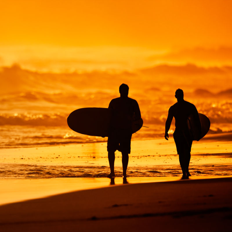 Surfers-At-Sunset-on-Beach-Silhouette