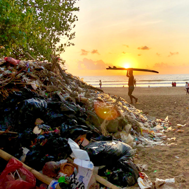 Śmieci gromadzą się na plaży Kuta o zachodzie słońca na Bali