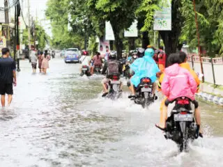 Tourists Surfing In The Street As Bali Resort Floods