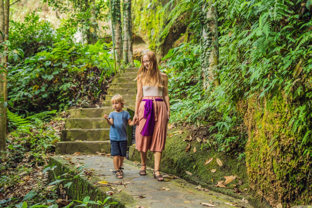 Woman and Son walk through jungle in Bali as tourists.jpg