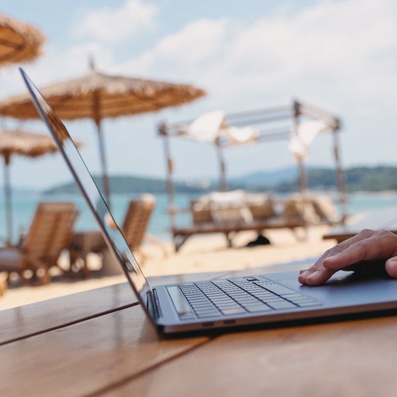 Digital-nomad-on-laptop-at-table-on-Bali-beach