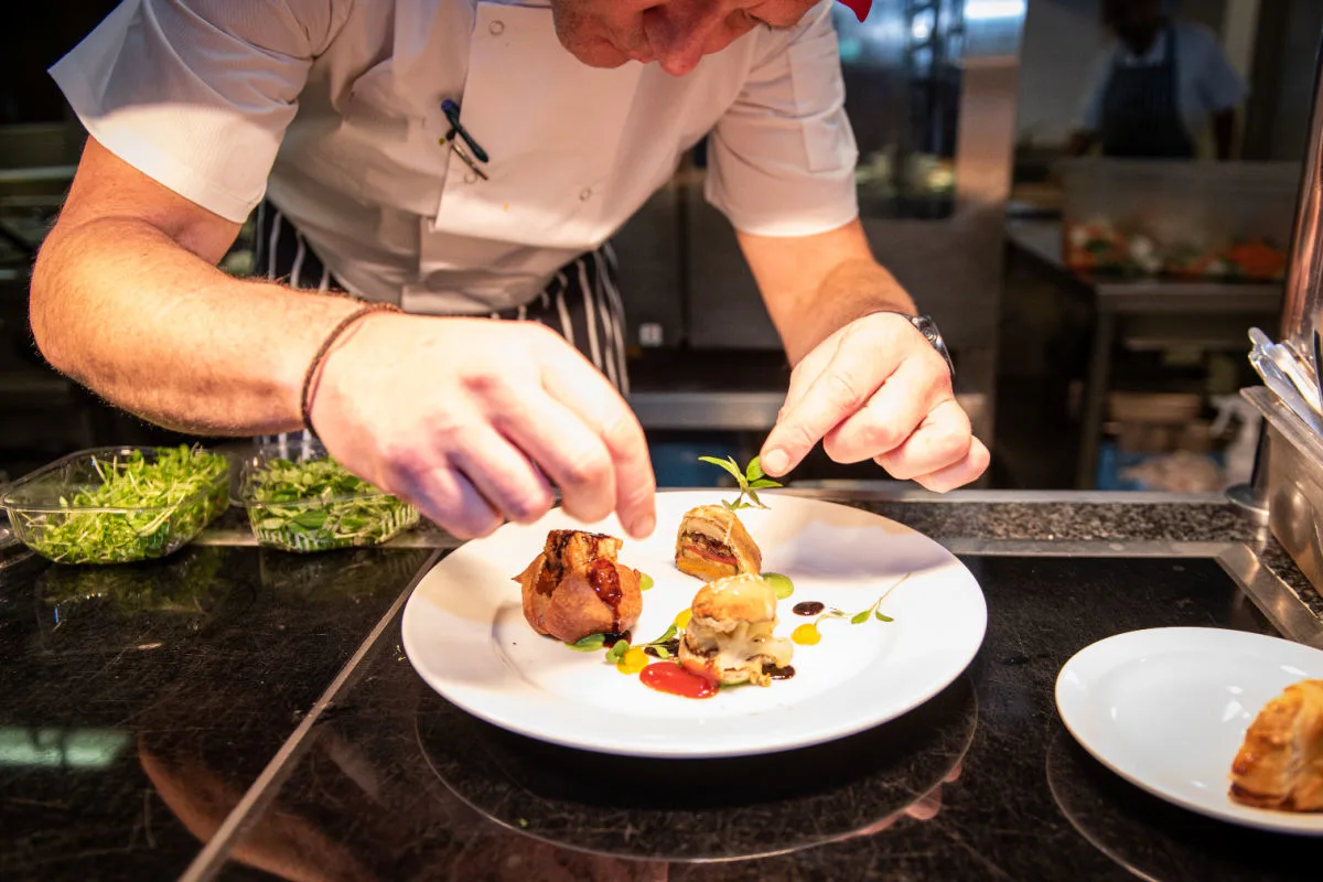 Chef serves food at kitchen pass.jpg