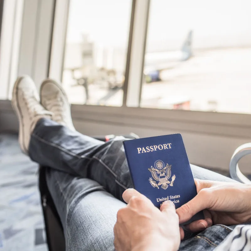 American-Passport-Holder-Sits-Waiting-at-Airport