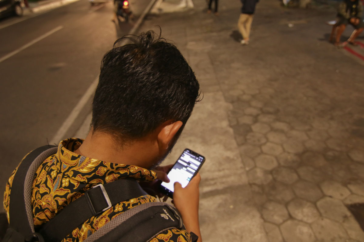 Indonesian Man Looks At Smartphone