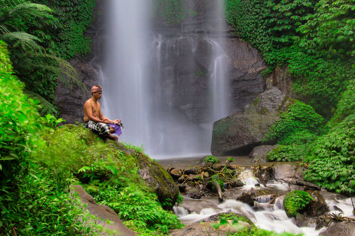 Man Meditates at Waterfall in Munduk.jpg