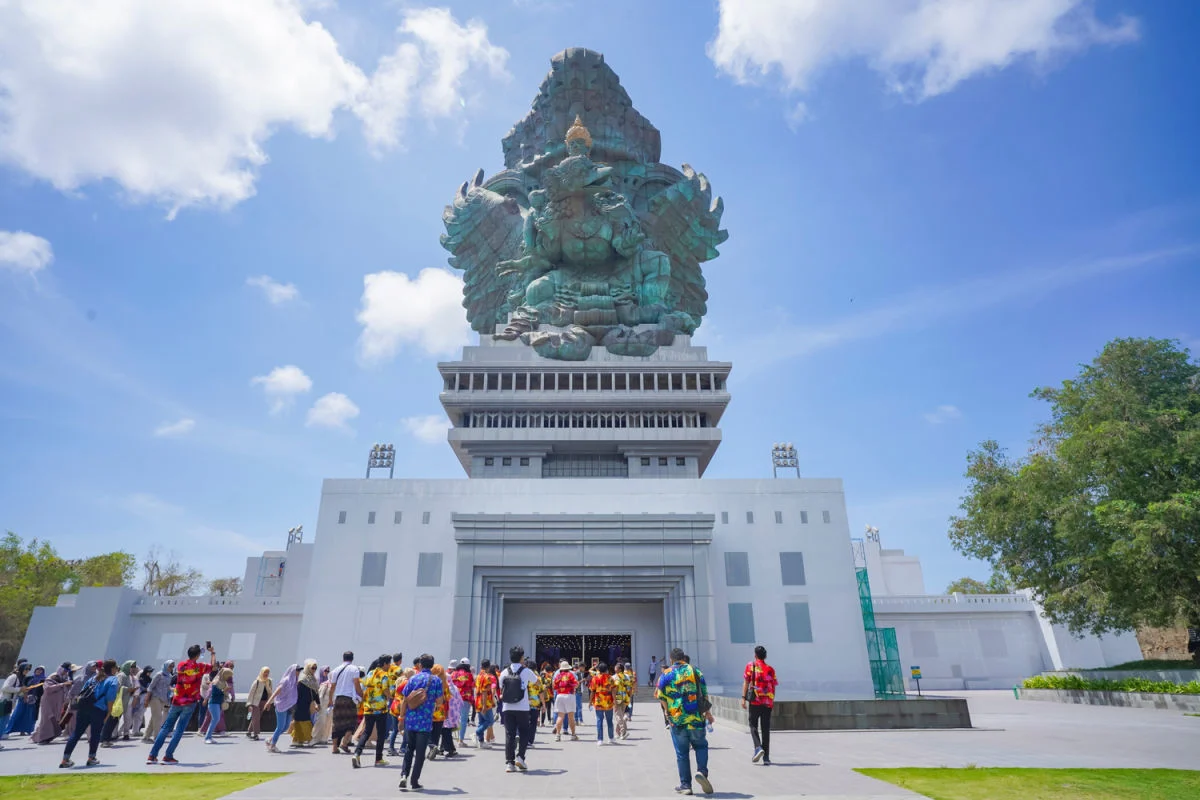 Tourists Stand Beneath the GWK Cultural Park Statue in Bali .jpg
