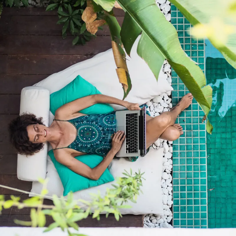 Woman-Sits-At-Pool-in-Bali-Villa-On-Laptop-Digital-Nomad