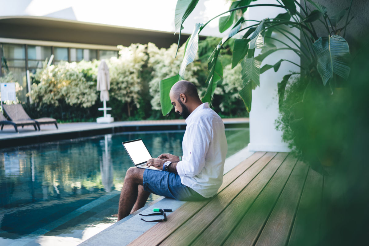 Digital Nomad works on laptop by Bali pool.jpg