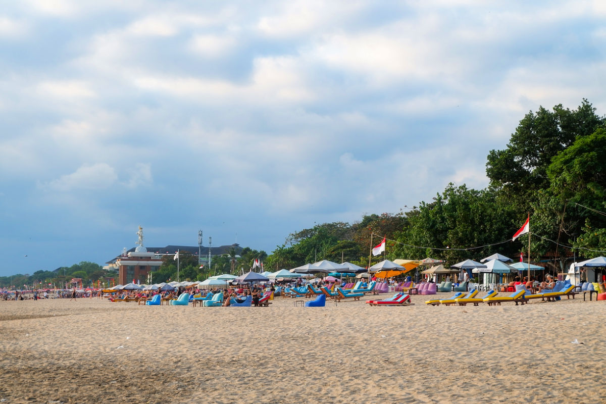 Seminyak Beach Tourists relax With Tsunami Shelter in Distance.jpg