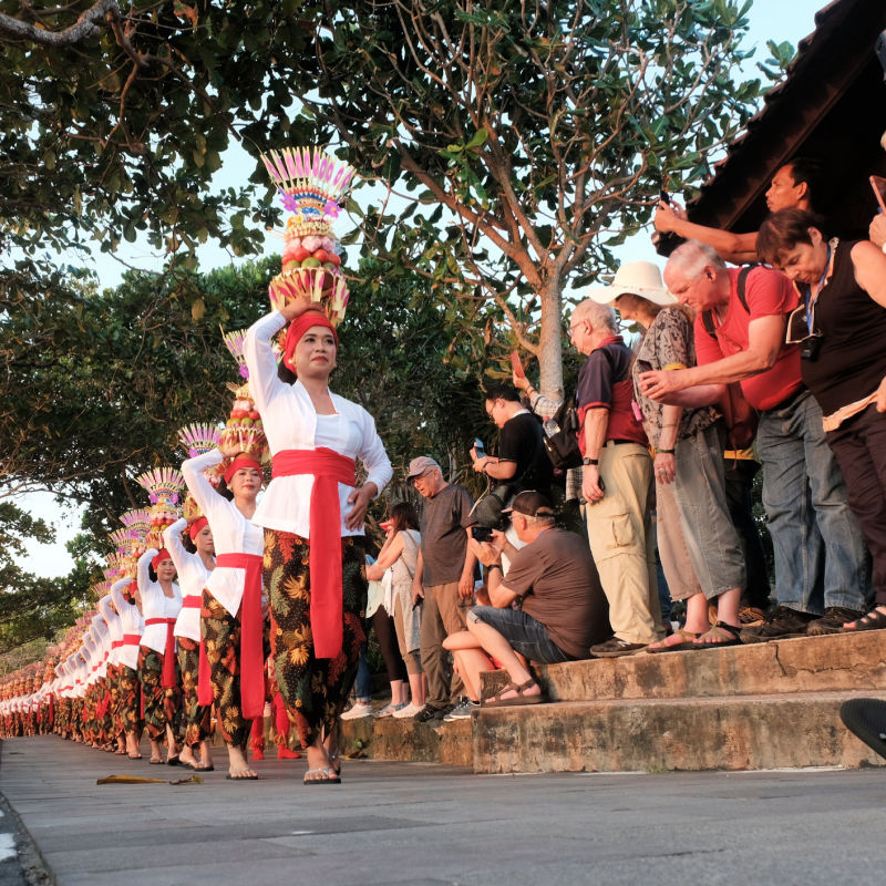 Balinese-Women-In-Cultural-Parade-While-Bali-Tourists-Watch