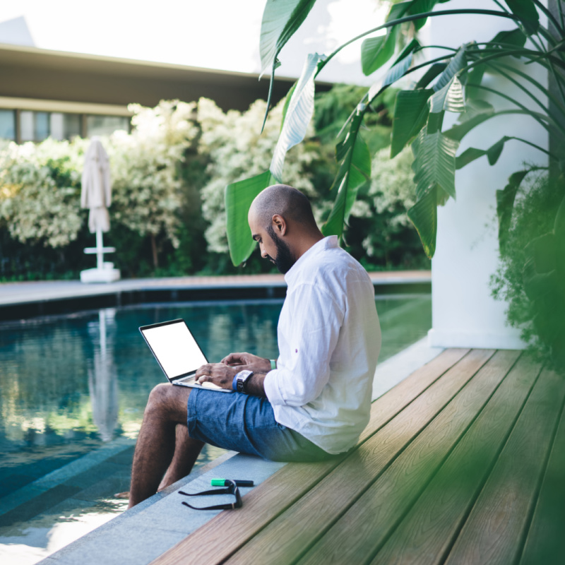 Digital-Nomad-works-on-laptop-by-Bali-pool