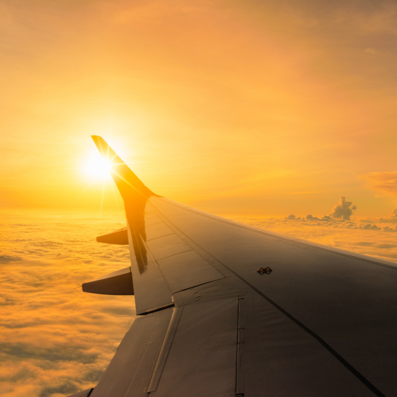 Plane-Wing-In-Sky-At-Sunset