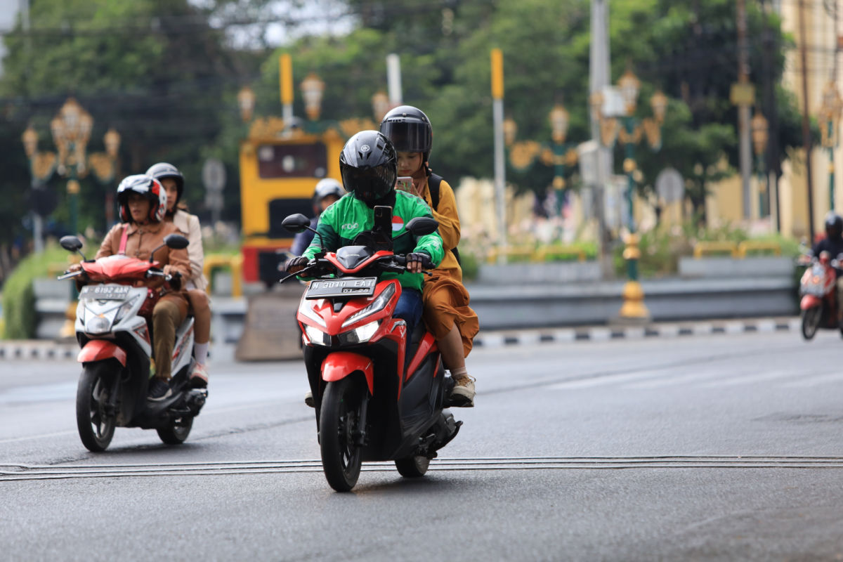 Two Mopeds Drive On Main Road.jpg