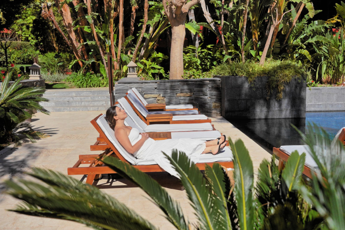 Woman Sits On Sun Lounger By Pool Wellness Bali.jpg