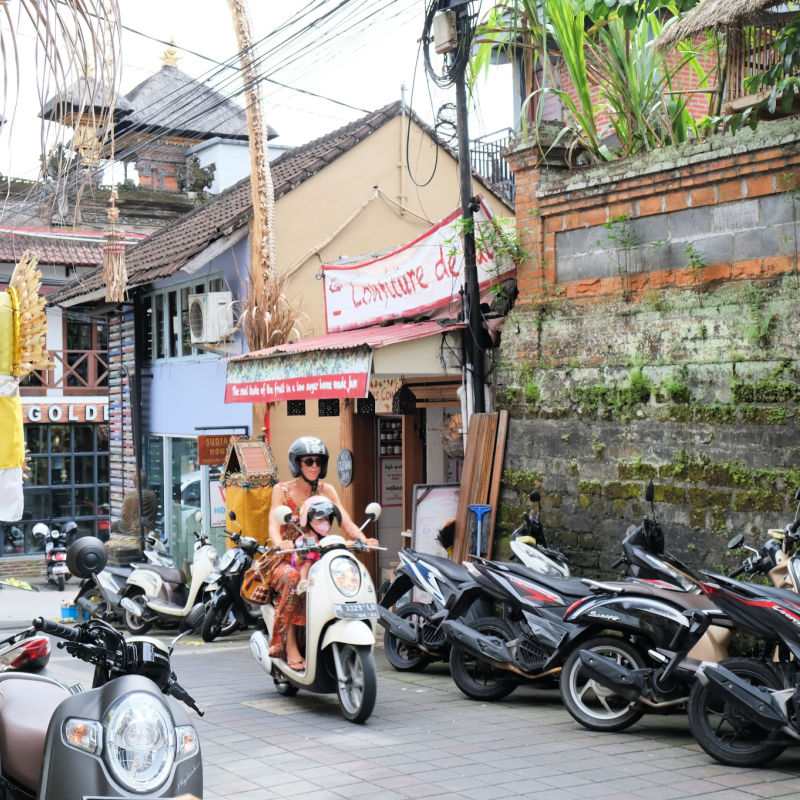 Touirst-Woman-Drive-Moped-Honda-Scoopy-Through-Ubud-Bali