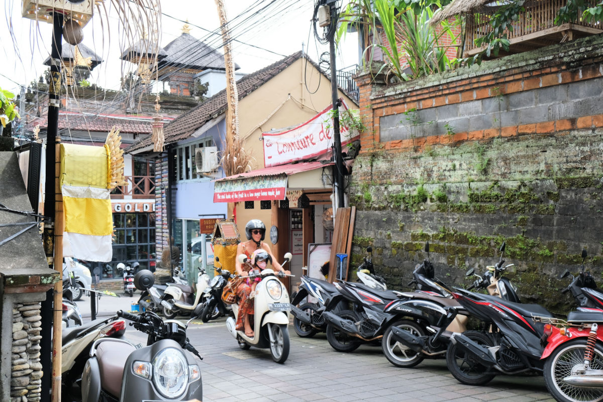 Touirst Woman Drive Moped Honda Scoopy Through Ubud Bali.jpg