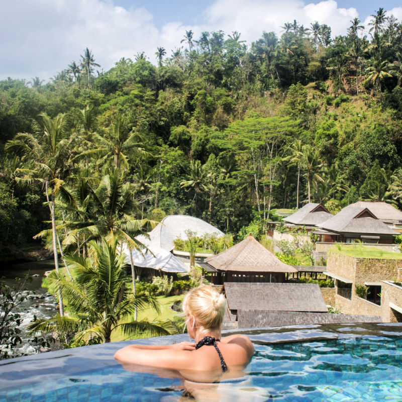 Woman-in-infinity-pool-looking-out-at-Bali-Ubud-jungle-at-hotel