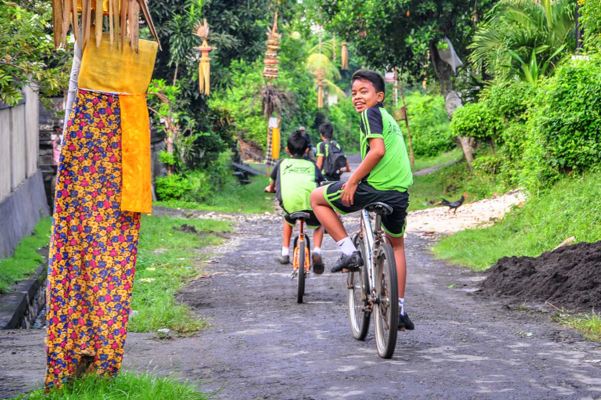 Bali Kids Ride Bikes Down Alleyway.jpg