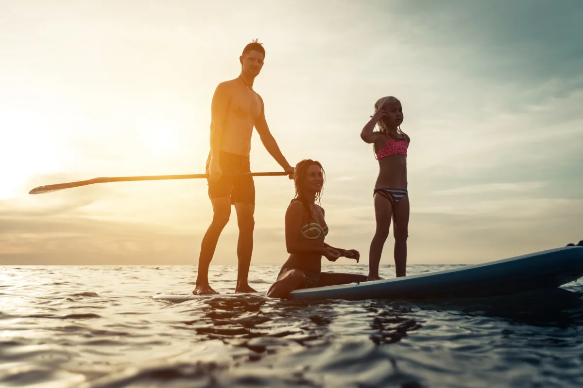 Dad and Kids family on Surf paddle board at beach sunset.jpg