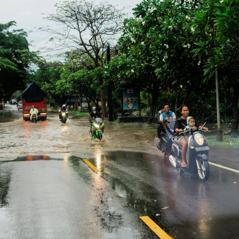 Drivers-Drive-Moped-In-Rain-Storm-Flood-Bali