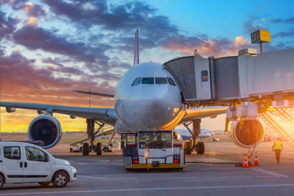 Plane With Boarding Tunnel At Airport.jpg