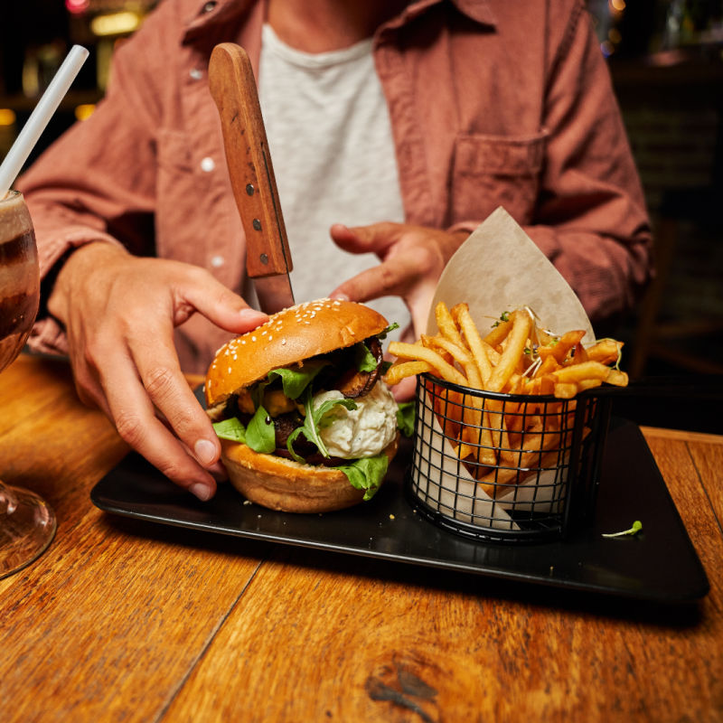 Man-Eats-Burger-and-Chips-Food-Pub-Bali