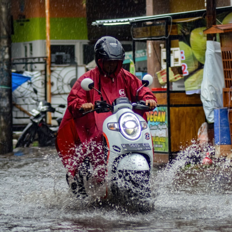 Moped-Driver-Drives-Thorugh-Rain-and-Flooded-Road-in-Bali