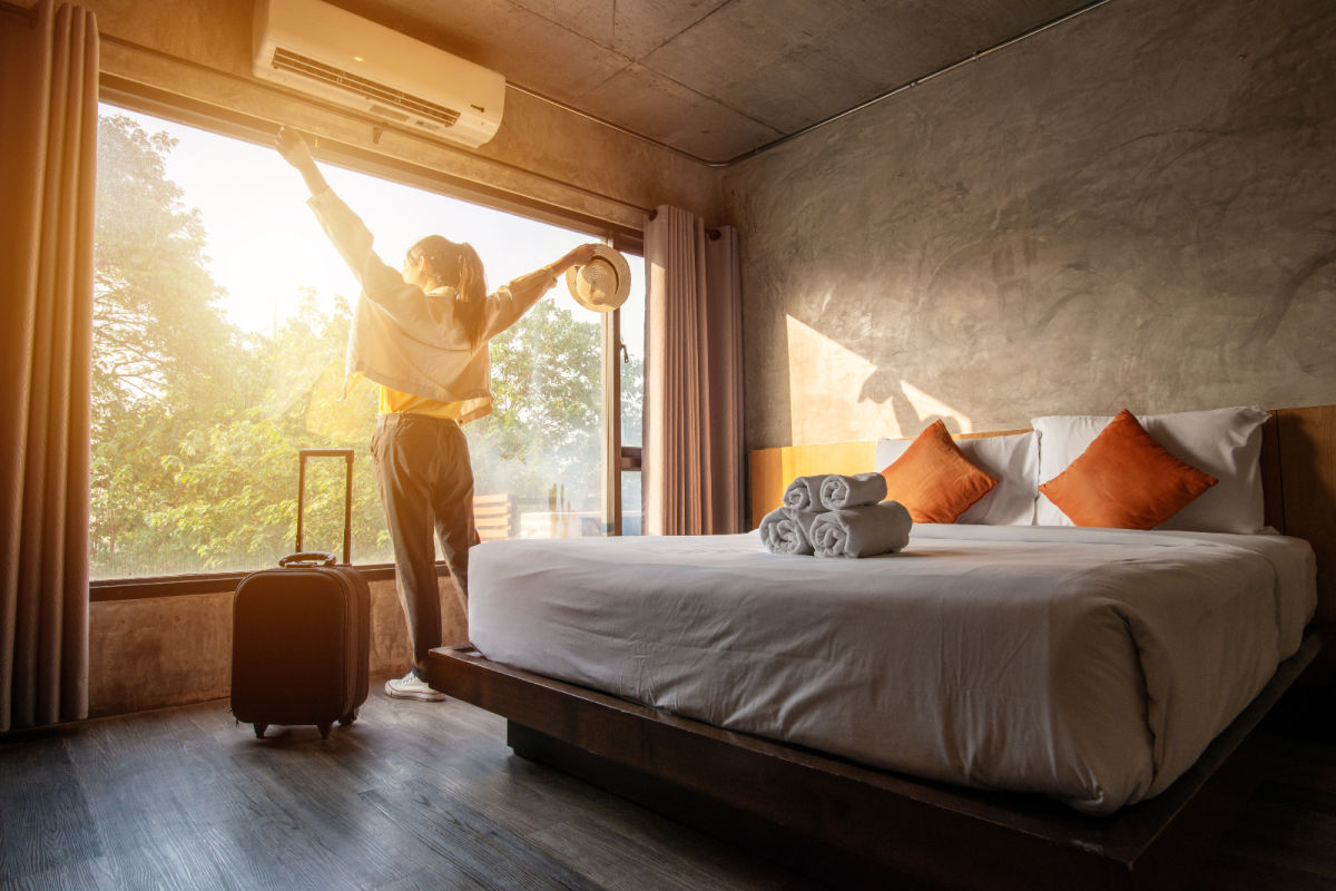 Woman Stands In Hotel Room Window