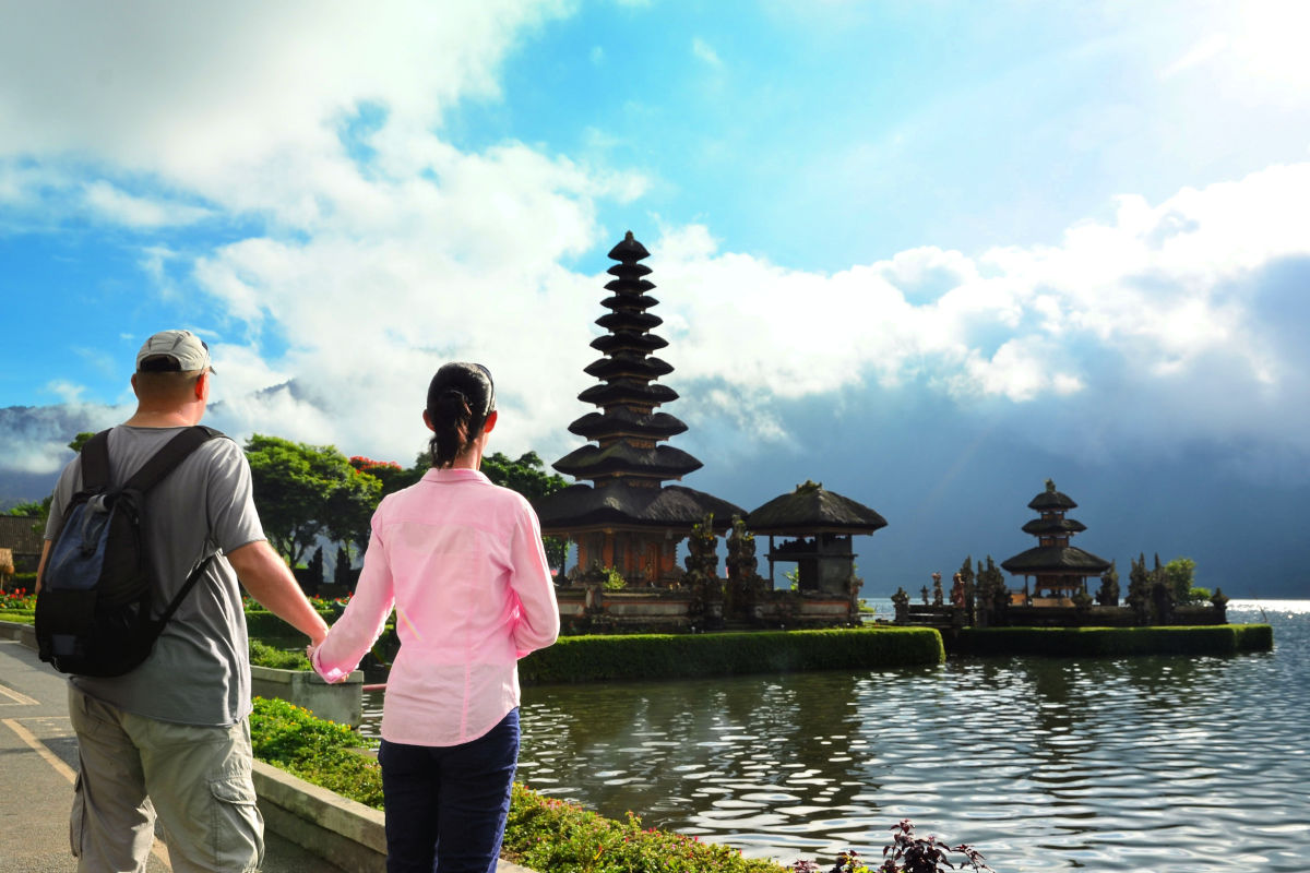 Tourists Stand Hand in Hand Looking at Temple in Bedugul