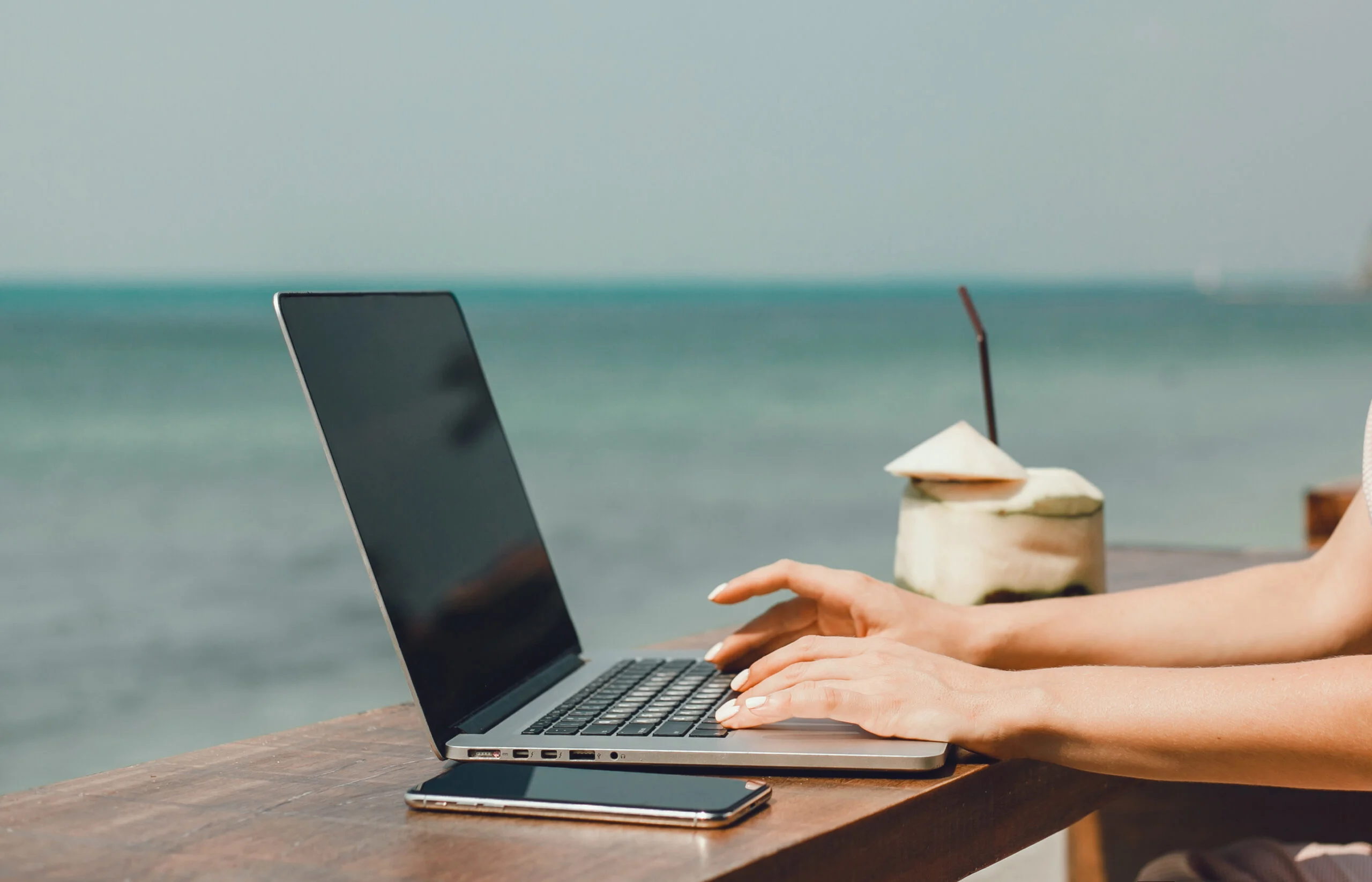 Hands on Laptop with phone overlooking Bali sea digital nomad.jpg