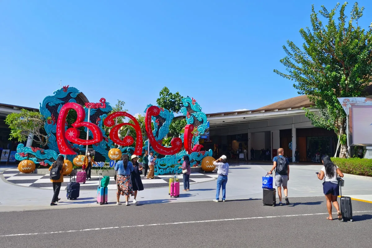 Bali Sign Outside Airport With Tourists