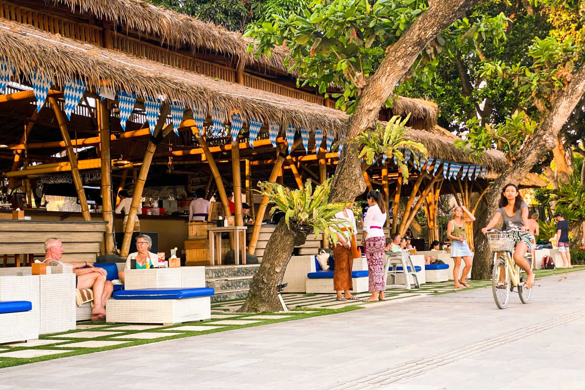 Woman Rides Bike Down Sanur Beachfront Beach Walk in Bali.jpg