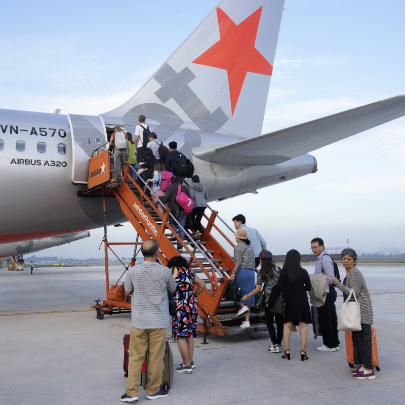 Jetstar Plane on Runway With Passengers Boarding.jpg