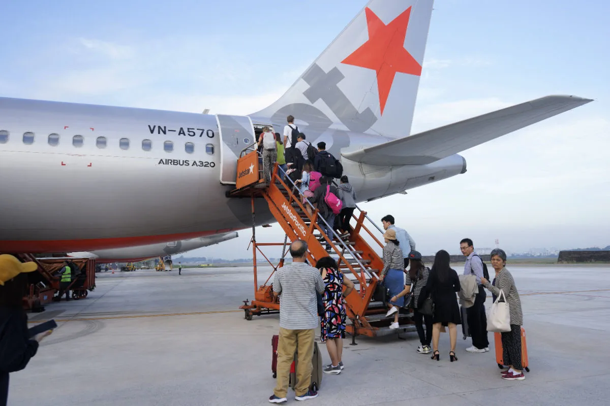 Jetstar Plane on Runway With Passengers Boarding.jpg