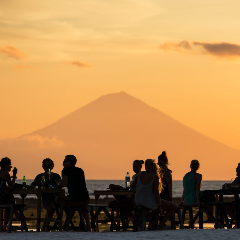 Tourists on Bali Beach Close to Mountain Silhouette