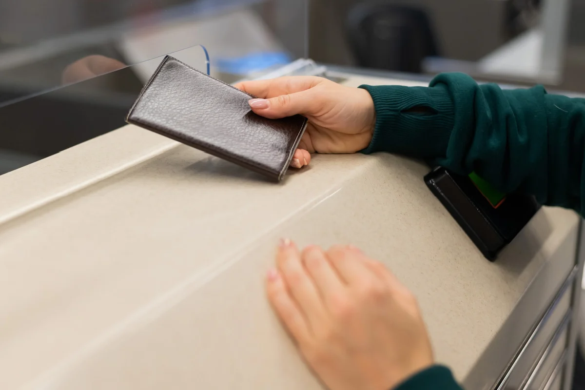 Tourist Hands Passport Over At Immigration Counter