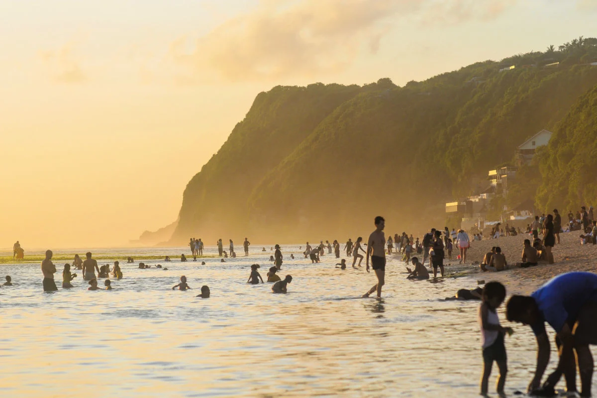 Tourists Enjoy Sunset At Uluwatu Beach Bali.jpg