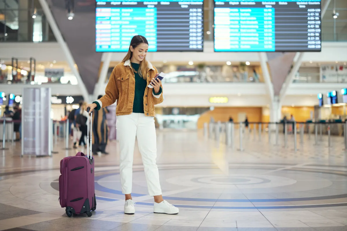 Female Traveler Looks at Phone At Airport.jpg