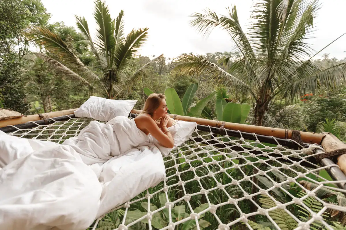 Woman on Jungle Net Deck At Eco Hotel in Bali