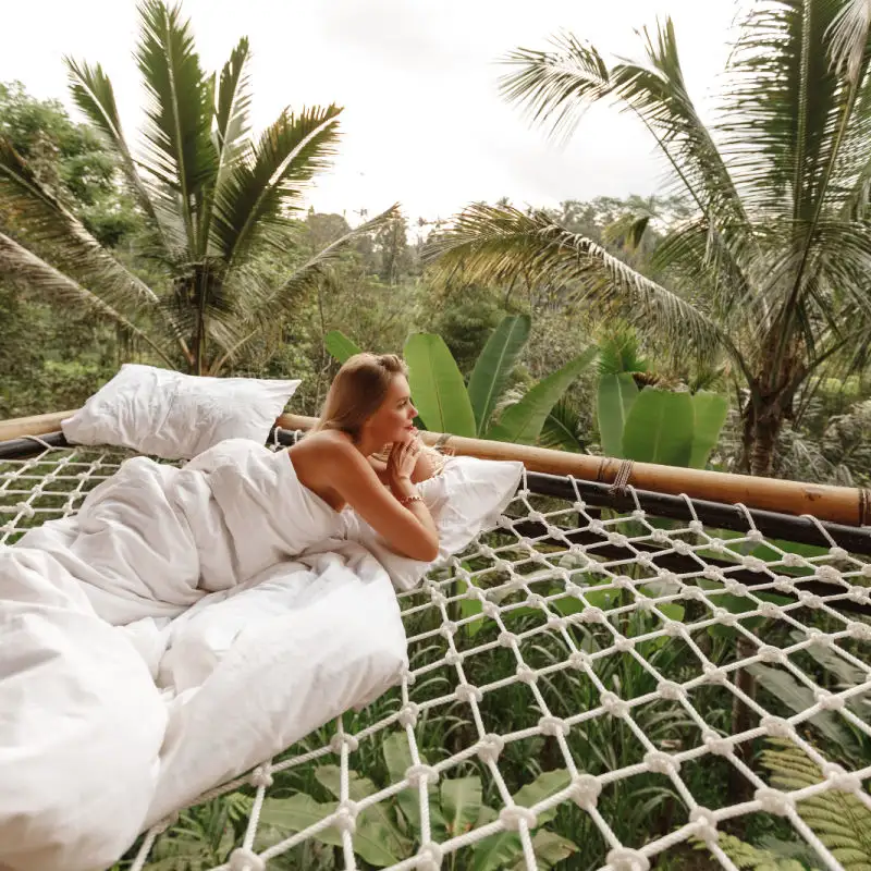 Woman on Jungle Net Deck At Eco Hotel in Bali