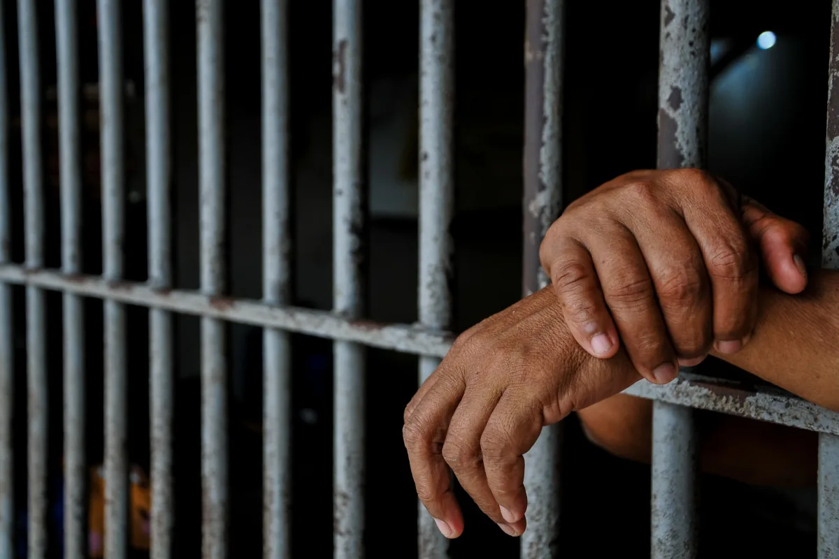 Jail Prison Hands Between Bars.jpg