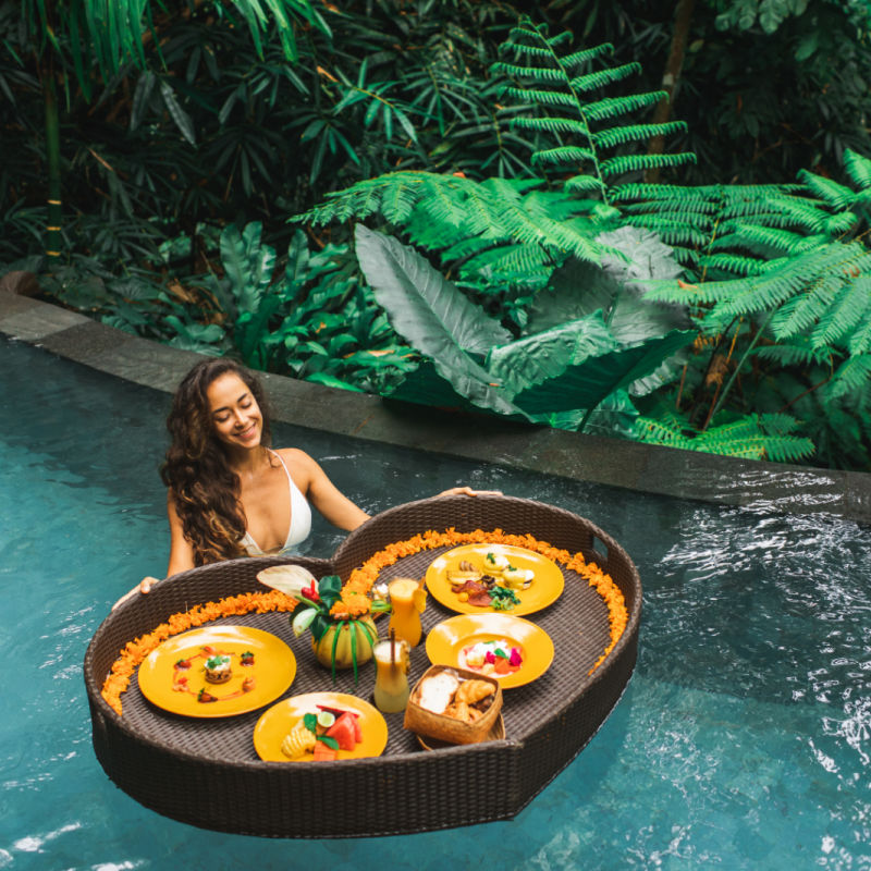 Women Having Bali Floating Breakfast in Luxury Hotel Pool