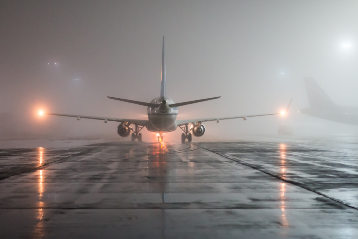 Airplane in Fog Storm Bad Weather at Bali Airport.jpg